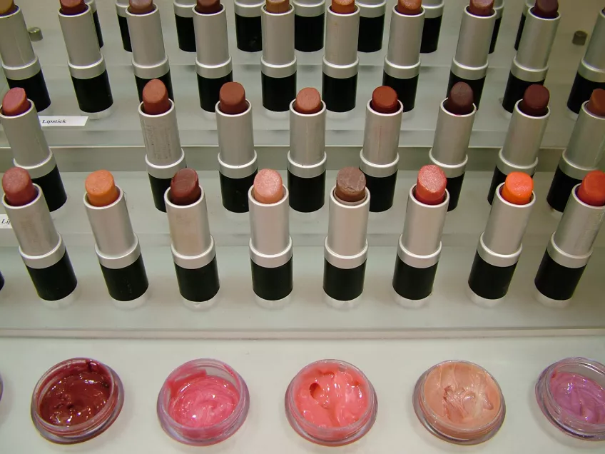 Lipsticks and lip gloss at a makeup counter. Photo.